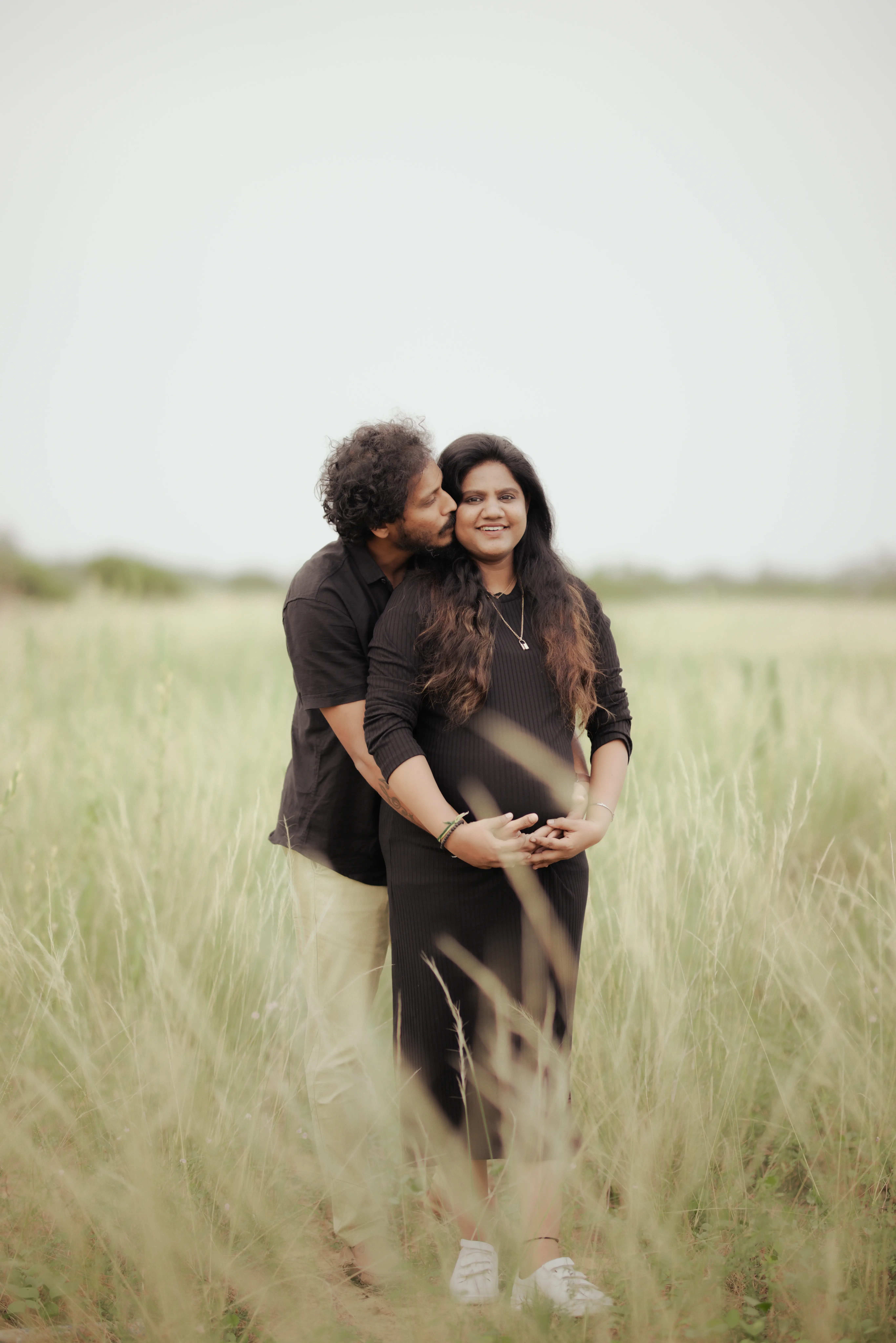 Sunset maternity shoot with silhouette of expecting mother holding her belly.